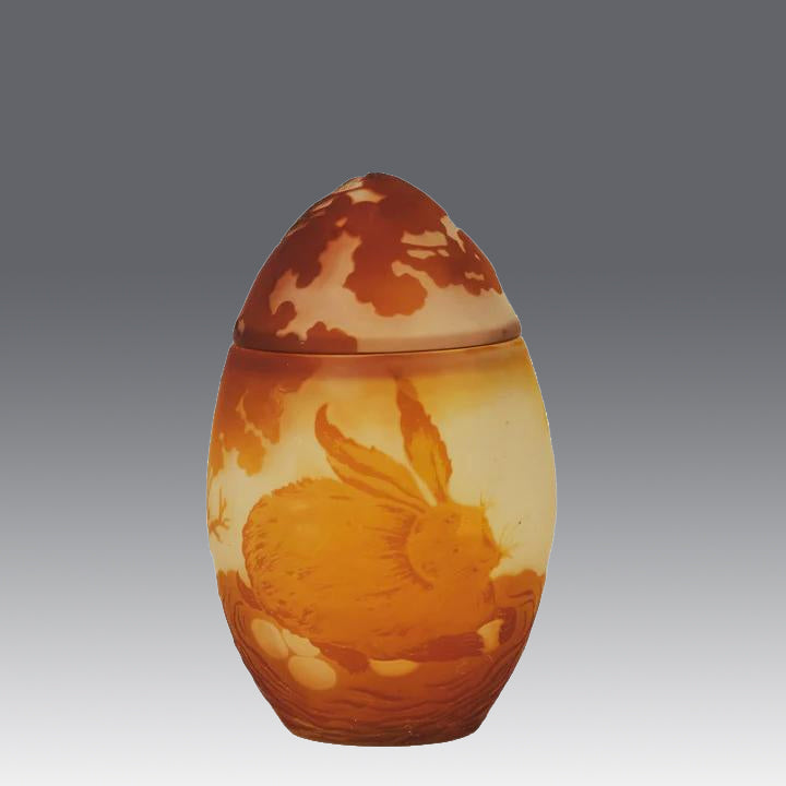 Easter  Egg Vase with Bunny by Émile Gallé. A beautiful and very rare early 20th Century cameo glass lidded egg shaped vase acid cut and etched with an Easter bunny sitting on a nest of eggs under the boughs of some trees in deep orange on a cream/ivory field