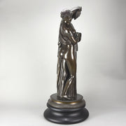 Callipygian Venus an Antique Bronze Figure depicting a partially draped woman, raising her light peplos (draped clothing) to uncover her hips and buttocks, and looking back and down over her shoulder