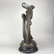 Callipygian Venus an Antique Bronze Figure depicting a partially draped woman, raising her light peplos (draped clothing) to uncover her hips and buttocks, and looking back and down over her shoulder