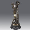 Callipygian Venus an Antique Bronze Figure depicting a partially draped woman, raising her light peplos (draped clothing) to uncover her hips and buttocks, and looking back and down over her shoulder
