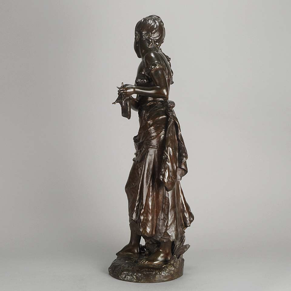 An antique bronze figures Femme avec chat by H Moreau A charming bronze study of a young girl looking down at her feet where her cat is standing exhibiting excellent rich brown patina and very fine hand finished detail
