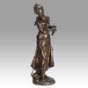 An antique bronze figures Femme avec chat by H Moreau A charming bronze study of a young girl looking down at her feet where her cat is standing exhibiting excellent rich brown patina and very fine hand finished detail