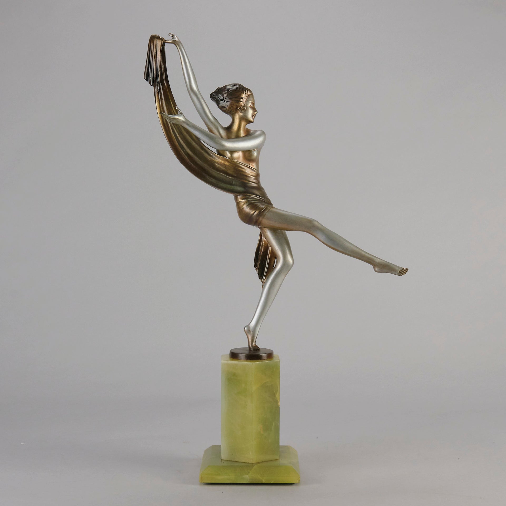 Charlotte by Josef Lorenzl a fabulous early 20th Century Art Deco cold painted bronze figure of a young woman holding an energetic pose lifting her shawl which is wrapped around her midriff.