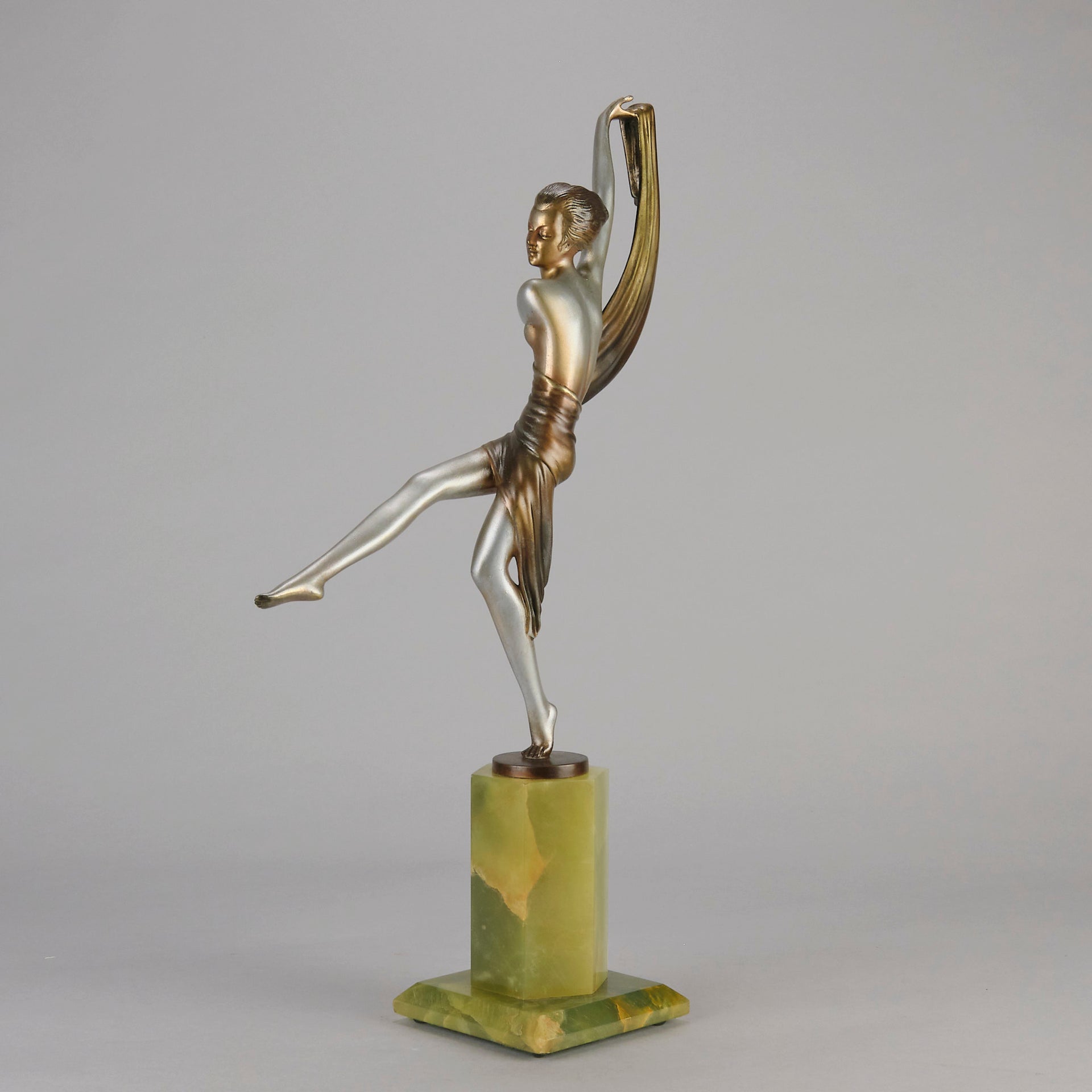 Charlotte by Josef Lorenzl a fabulous early 20th Century Art Deco cold painted bronze figure of a young woman holding an energetic pose lifting her shawl which is wrapped around her midriff.