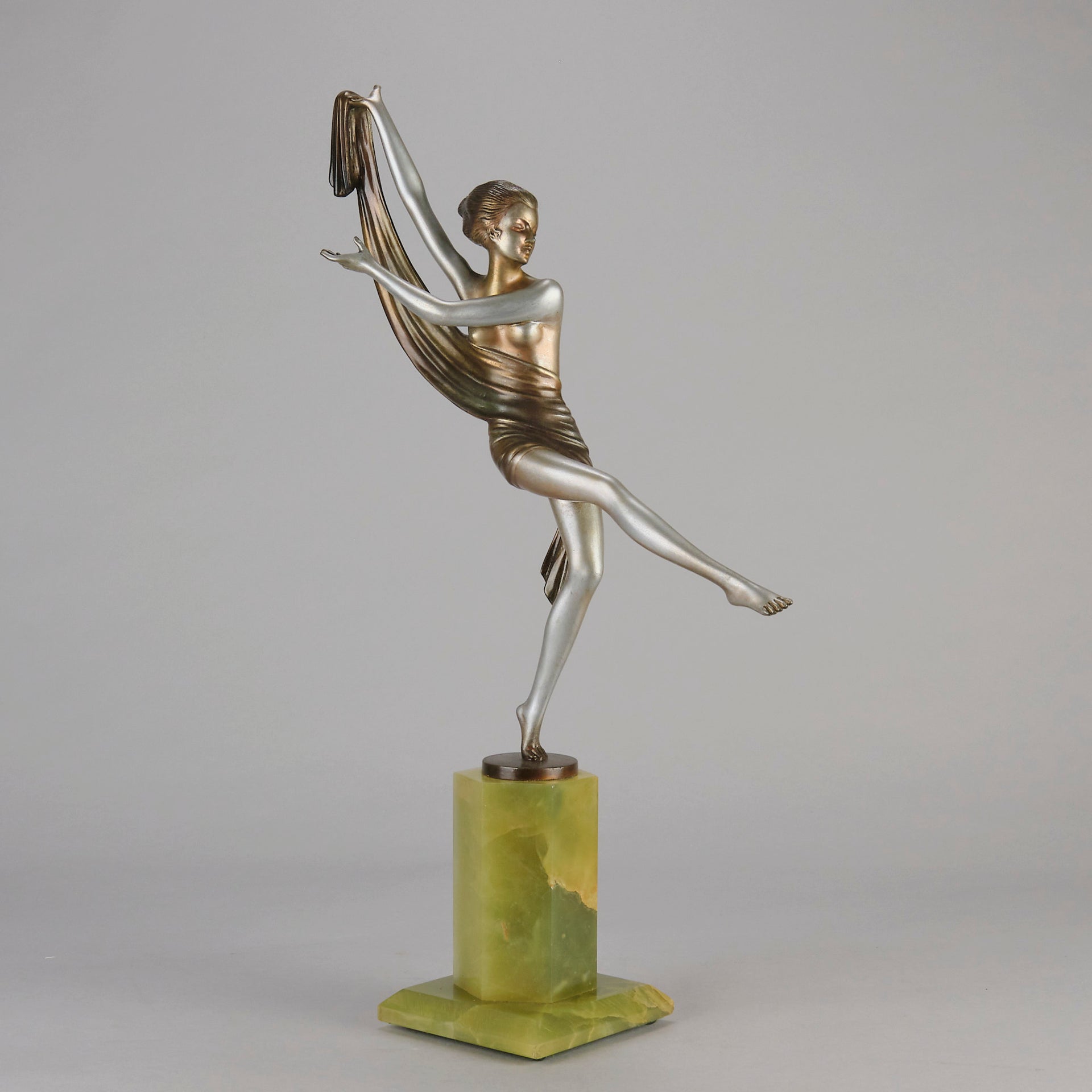 Charlotte by Josef Lorenzl a fabulous early 20th Century Art Deco cold painted bronze figure of a young woman holding an energetic pose lifting her shawl which is wrapped around her midriff.