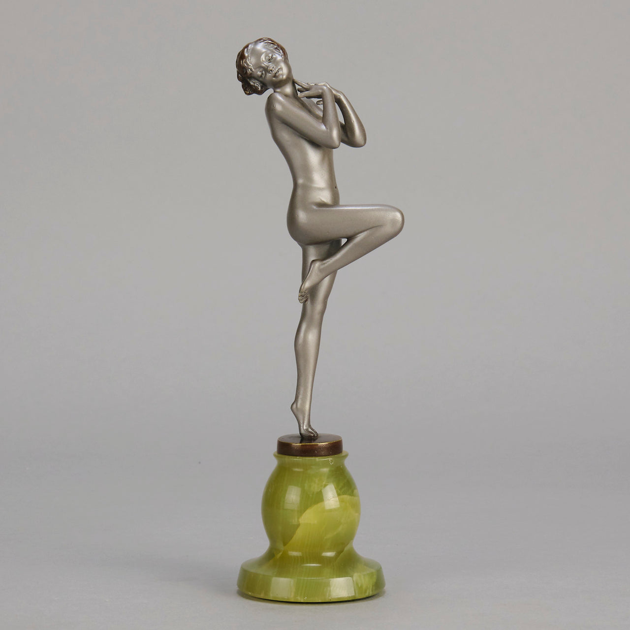 Art Deco Sculpture - Deco Dancer  by Josef Lorenzl  a cold painted bronze figure of a young woman holding a dancing pose with her hands lifted across her chest. The bronze figure with excellent colour and very fine hand chased surface detail, raised on a green onyx base  