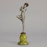 Art Deco Sculpture - Deco Dancer  by Josef Lorenzl  a cold painted bronze figure of a young woman holding a dancing pose with her hands lifted across her chest. The bronze figure with excellent colour and very fine hand chased surface detail, raised on a green onyx base  