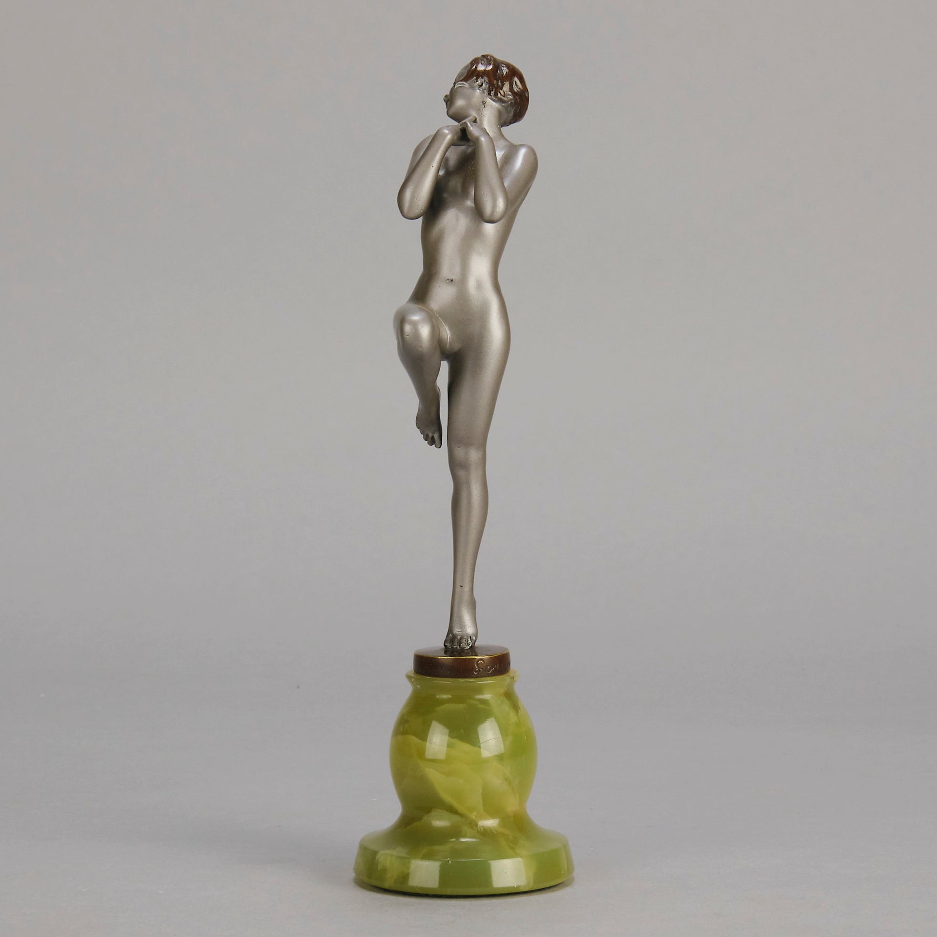 Art Deco Sculpture - Deco Dancer  by Josef Lorenzl  a cold painted bronze figure of a young woman holding a dancing pose with her hands lifted across her chest. The bronze figure with excellent colour and very fine hand chased surface detail, raised on a green onyx base  
