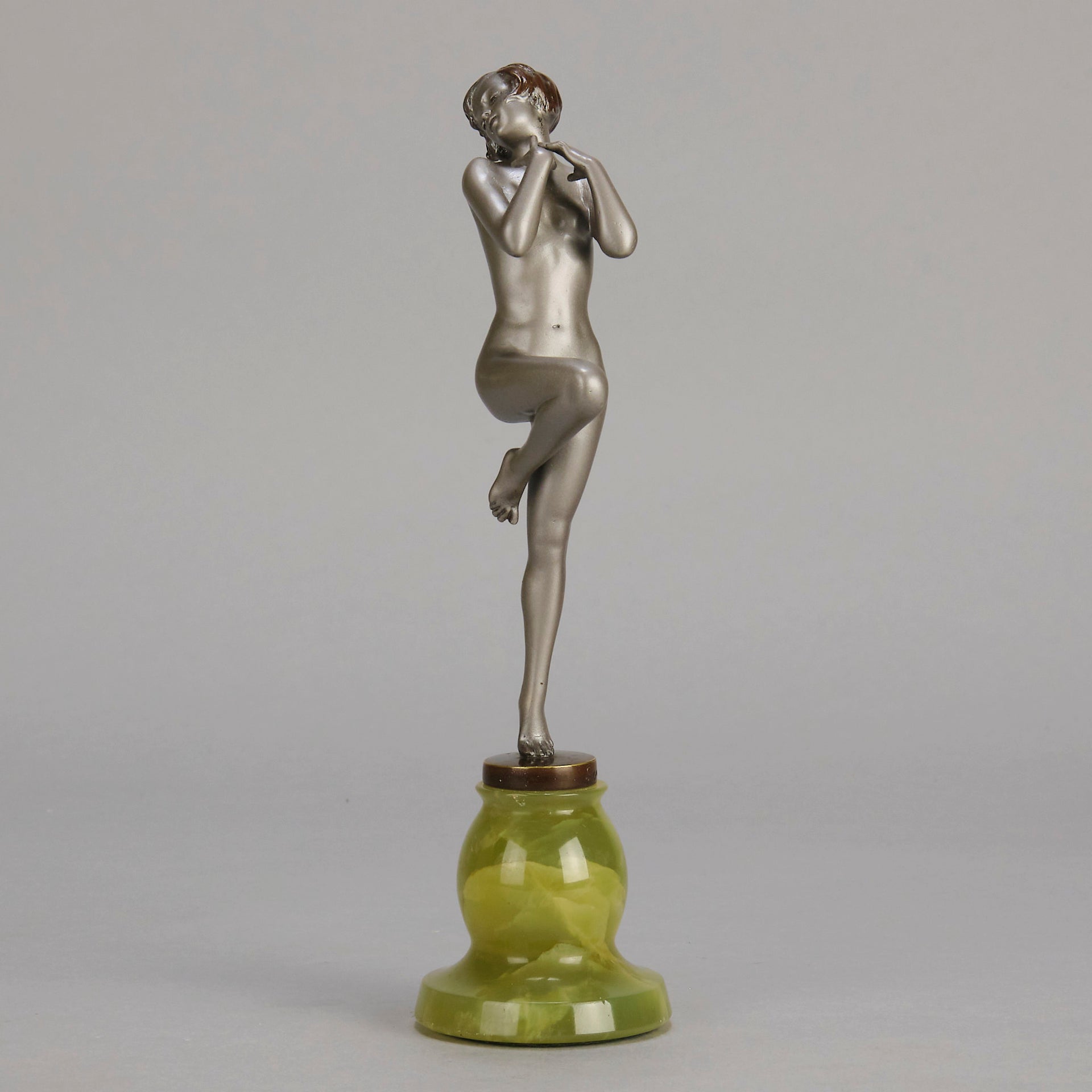Art Deco Sculpture - Deco Dancer  by Josef Lorenzl  a cold painted bronze figure of a young woman holding a dancing pose with her hands lifted across her chest. The bronze figure with excellent colour and very fine hand chased surface detail, raised on a green onyx base  