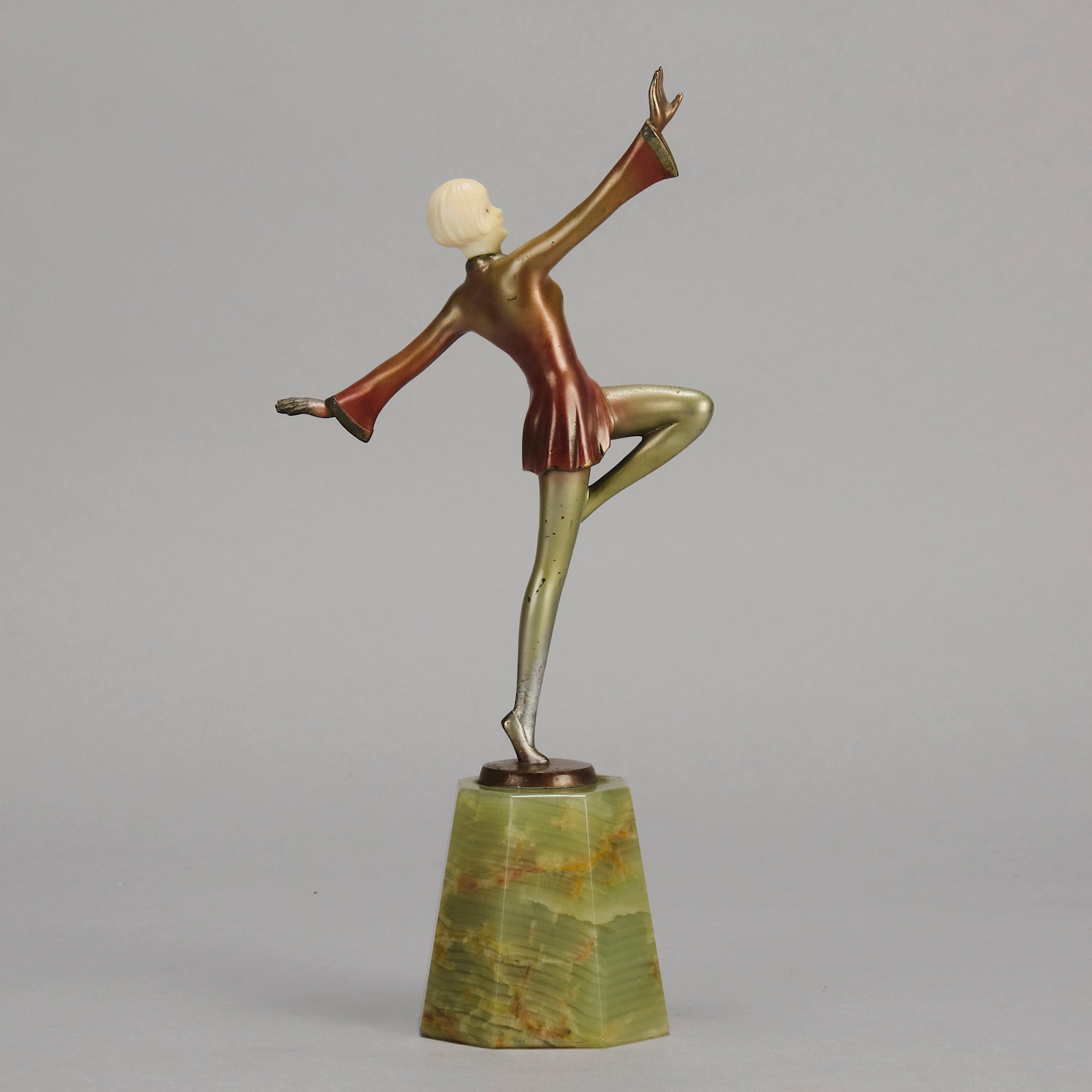 Helga by Josef Lorenzl An Art Deco Bronze and ivory igure of a beautiful dancer holding an elegant pose exhibiting excellent colour and very fine hand chased surface detail, raised on a green onyx base 
