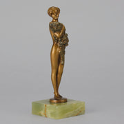 The Bouquet by Joseph Lorenzl an elegant early 20th Century Art Deco cold painted bronze figure of a young beauty holding a large bouquet of flowers covering her modesty raised on a green onyx base 