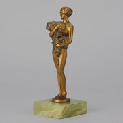 The Bouquet by Joseph Lorenzl an elegant early 20th Century Art Deco cold painted bronze figure of a young beauty holding a large bouquet of flowers covering her modesty raised on a green onyx base 