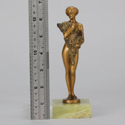 The Bouquet by Joseph Lorenzl an elegant early 20th Century Art Deco cold painted bronze figure of a young beauty holding a large bouquet of flowers covering her modesty raised on a green onyx base 