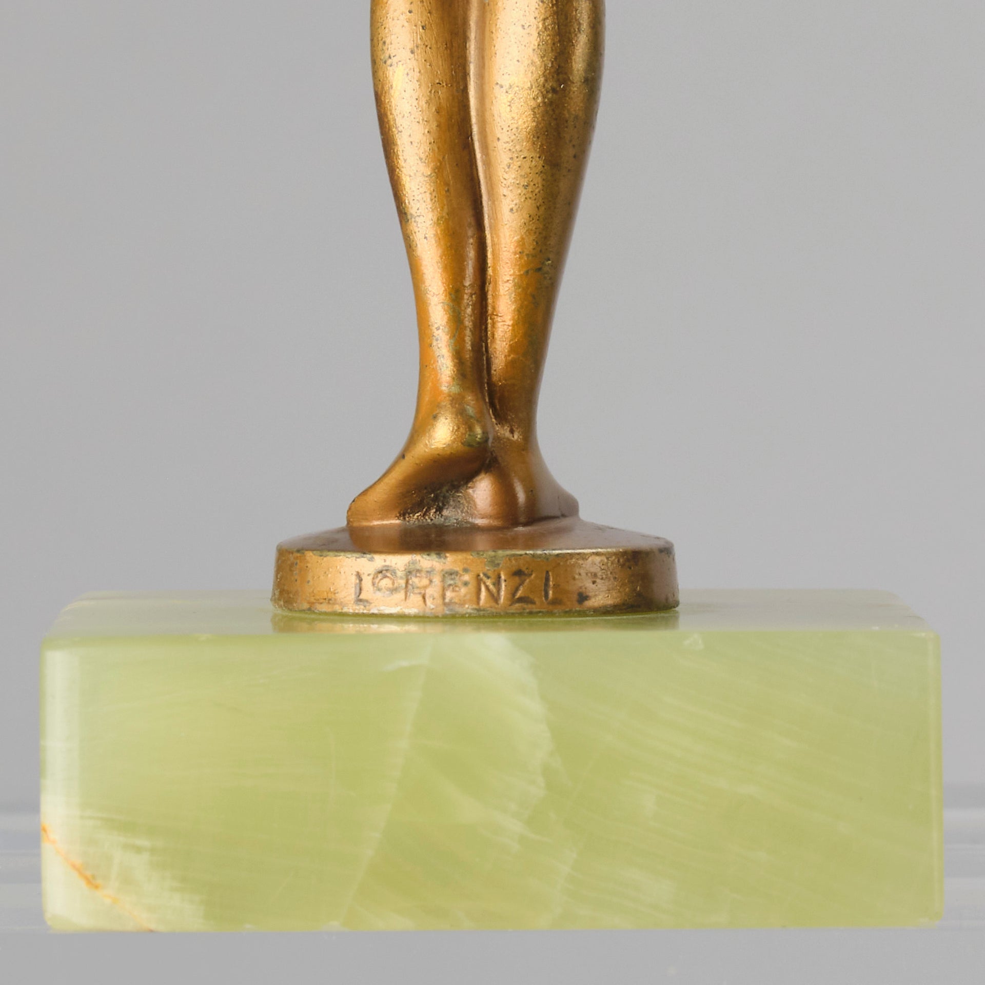 The Bouquet by Joseph Lorenzl an elegant early 20th Century Art Deco cold painted bronze figure of a young beauty holding a large bouquet of flowers covering her modesty raised on a green onyx base 