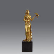 Femme avec Oiseau by Pierre Laurel an antique bronze figure of a semi clad young woman holding a bird in classic high Art Deco pose with excellent gilt patination and intricate surface detail on a square shaped black marble base 
