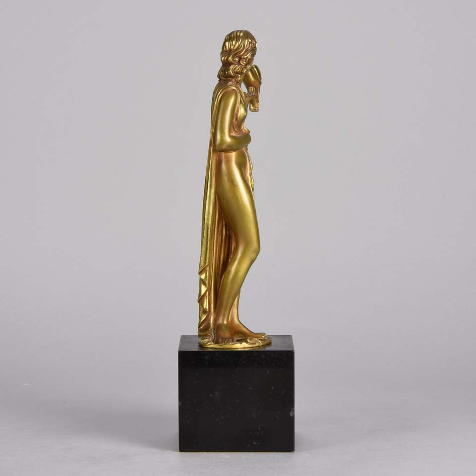 Femme avec Oiseau by Pierre Laurel an antique bronze figure of a semi clad young woman holding a bird in classic high Art Deco pose with excellent gilt patination and intricate surface detail on a square shaped black marble base 