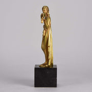 Femme avec Oiseau by Pierre Laurel an antique bronze figure of a semi clad young woman holding a bird in classic high Art Deco pose with excellent gilt patination and intricate surface detail on a square shaped black marble base 