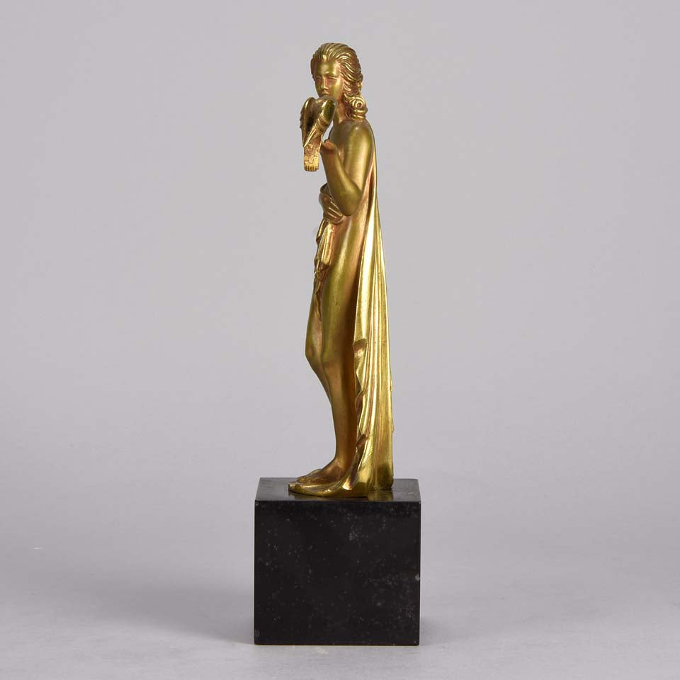 Femme avec Oiseau by Pierre Laurel an antique bronze figure of a semi clad young woman holding a bird in classic high Art Deco pose with excellent gilt patination and intricate surface detail on a square shaped black marble base 