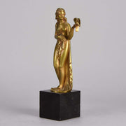 Femme avec Oiseau by Pierre Laurel an antique bronze figure of a semi clad young woman holding a bird in classic high Art Deco pose with excellent gilt patination and intricate surface detail on a square shaped black marble base 