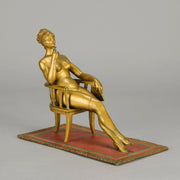 Vienna Bronze Seated Lady - an early 20th Century cold-painted Austrian bronze figure of an attractive lady seated on an arm chair wearing only a pair of stockings and heals, holding a book whilst enjoying a cigarette